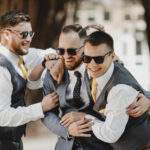 Groomsmen,In,Black,Sunglasses,Hug,Groom,Tightly,Posing,In,The